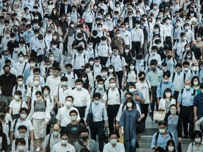Commuters wear masks at a train station in Tokyo on July 28, 2021, a day after the city reported a record 2,848 new daily cases of Covid-19 coronavirus.