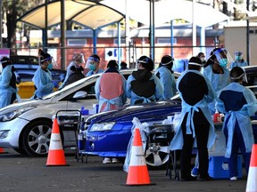 Health workers takes swab samples from residents at a Covid-19 drive-through testing clinic in Sydney on July 28, 2021.