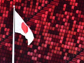 An overview shows the Japanese national flag with empty stands during the opening ceremony of the Tokyo 2020 Olympic Games.
