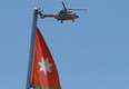 Royal Jordanian Air Force AS332 Super Puma helicopter flies over the State Security Court, where the trial of two officials accused of helping Jordan's Prince Hamzah try to overthrow his half-brother King Abdullah II began, in Amman on June 21, 2021.