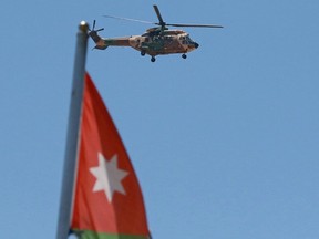 Royal Jordanian Air Force AS332 Super Puma helicopter flies over the State Security Court, where the trial of two officials accused of helping Jordan's Prince Hamzah try to overthrow his half-brother King Abdullah II began, in Amman on June 21, 2021.
