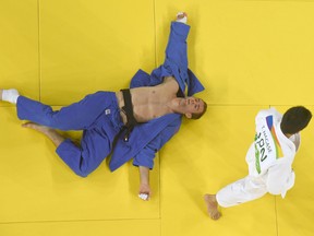 A overview shows Japan's Takanori Nagase (white) competing with Canada's Antoine Valois-Fortier during their men's -81kg judo contest repechage match of the Rio 2016 Olympic Games.