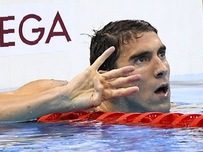 Michael Phelps puts up four fingers after winning his fourth Gold medal during the Olympic Games in Rio De Janeiro on Aug. 11, 2016.