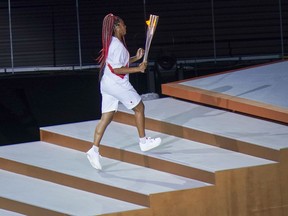 Naomi Osaka carries the flame during the Opening Ceremony for the Tokyo 2020 Olympic Games on Friday. MUST CREDIT: Washington Post photo by Toni L. Sandys