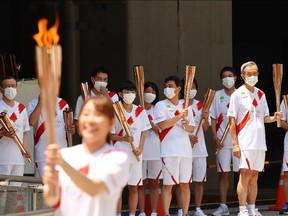 Tokyo 2020 Olympics - Arrival Ceremony for Tokyo 2020 Olympic Torch Relay - Shinjuku City, Tokyo, Japan - July 23, 2021 Torch bearers look on REUTERS/Edgar Su