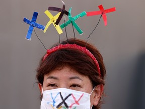 protester wearing a protective face mask during a rally near Akasaka State Guest where International Olympic Committee (IOC) President Thomas Bach attended a welcome ceremony.