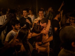 Two people hug in the middle of the dancefloor at Egg London nightclub in the early hours of July 19, 2021 in London, England. As of 12:01 on Monday, July 19, England will drop most of its remaining Covid-19 social restrictions, such as those requiring indoor mask-wearing and limits on group gatherings, among other rules. These changes come despite rising infections, pitting the country's vaccination programme against the virus's more contagious Delta variant.