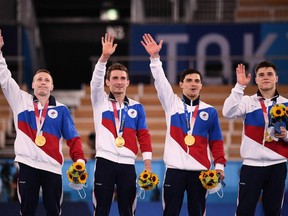 (From L) Gold medallists Russia's David Belyavskiy, Russia's Denis Abliazin, Russia's Artur Dalaloyan and Russia's Nikita Nagornyy celebrate on the podium after winning the artistic gymnastics men's team final during the Tokyo 2020 Olympic Games at the Ariake Gymnastics Centre in Tokyo on July 26, 2021.