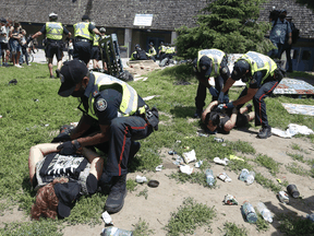 Toronto Police arrest a man after being met with resistance as they prepare to enter a tent while by-law officers moved in on the homeless encampment outside Lamport Stadium on Wednesday July 21, 2021.