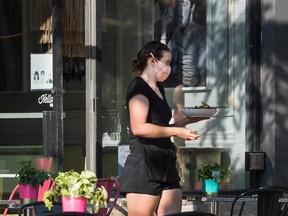 A server delivers food at a restaurant in Oakville, Ont. Small businesses are asking Ottawa not to withdraw subsidies just yet.