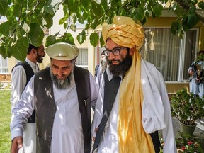 This handout photo released by the Arabic Twitter account of the "Islamic Emirate of Afghanistan" on August 18, 2021 shows a Taliban delegation led by the head of the negotiating team Anas Haqqani (R) meeting with former Afghan government officials including the former senate (Meshrano Jirga) chairman Fazal Hadi Muslimyar (L) at an unspecified location in Afghanistan.