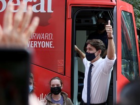 Justin Trudeau gives a thumbs up to supporters, accompanied by his daughter Ella-Grace, before embarking on his first election campaign visit, in Ottawa, Aug. 15, 2021.