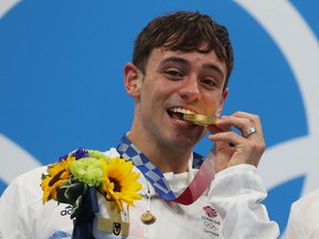 Tom Daley of Team Great Britain poses with the gold medal during the medal presentation for the Men's Synchronised 10m Platform Final.