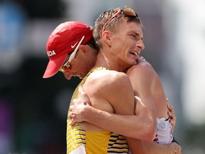 SAPPORO, JAPAN - AUGUST 06:  Silver medalist Jonathan Hilbert of Team Germany embraces bronze medalist Evan Dunfee of Team Canada after the Men's 50km Race Walk Final on day fourteen of the Tokyo 2020 Olympic Games at Sapporo Odori Park on August 06, 2021 in Sapporo, Japan.
