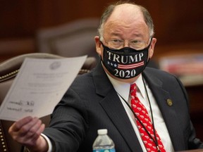 Republican Party of Florida National Committeeman Peter Feaman holds up the documents he and the rest of the 29 Florida Presidential Electors used to cast votes for Donald Trump and Mike Pence during a meeting of the electors at the Capitol in Tallahassee, Florida, on Monday, Dec. 14, 2020.