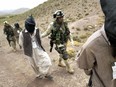 U.S. soldiers lead Afghan prisoners suspected of being Taliban or al-Qaida fighters, in Afghanistan in 2003.