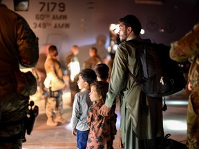 Evacuees from Afghanistan arriving at Ali Al Salem Air Base, Kuwait.  U.S. Air Force Handout photo via REUTERS