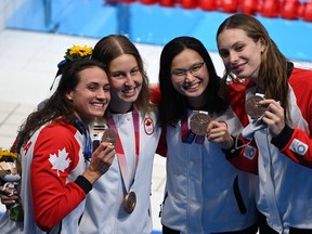 Bronze medallists (from L) Canada's Kylie Masse, Canada's Sydney Pickrem, Canada's Margaret MacNeil and Canada's Penny Oleksiak pose with their medals after the final of the women's 4x100m medley relay swimming event during the Tokyo 2020 Olympic Games at the Tokyo Aquatics Centre in Tokyo on August 1, 2021. (Photo by Jonathan NACKSTRAND / AFP) (Photo by JONATHAN NACKSTRAND/AFP via Getty Images)