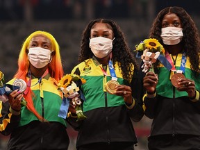 (From L) Second-placed Jamaica's Shelly-Ann Fraser-Pryce, firt-placed Jamaica's Elaine Thompson-Herah and third-placed Jamaica's Shericka Jackson celebrate on the podium with their medal after competing in the women's 100m event during the Tokyo 2020 Olympic Games at the Olympic Stadium in Tokyo on August 1, 2021. (Photo by Ina FASSBENDER / AFP) (Photo by INA FASSBENDER/AFP via Getty Images)