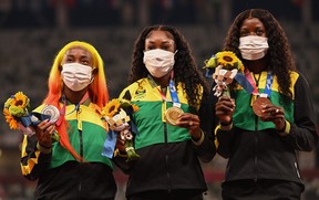 (From L) Second-placed Jamaica's Shelly-Ann Fraser-Pryce, firt-placed Jamaica's Elaine Thompson-Herah and third-placed Jamaica's Shericka Jackson celebrate on the podium with their medal after competing in the women's 100m event during the Tokyo 2020 Olympic Games at the Olympic Stadium in Tokyo on August 1, 2021. (Photo by Ina FASSBENDER / AFP) (Photo by INA FASSBENDER/AFP via Getty Images)