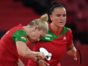 Hungary's Maria Fazekas (L) plays a shot during their women's team round of 16 table tennis match at the Tokyo Metropolitan Gymnasium during the Tokyo 2020 Olympic Games in Tokyo on August 1, 2021. (Photo by ADEK BERRY / AFP) (Photo by ADEK BERRY/AFP via Getty Images)