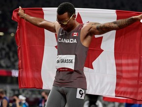 Canada's Andre De Grasse celebrates with the flag of Canada after placing third of the men's 100m final during the Tokyo 2020 Olympic Games at the Olympic Stadium in Tokyo on August 1, 2021. (Photo by Javier SORIANO / AFP) (Photo by JAVIER SORIANO/AFP via Getty Images)