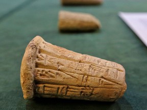 Mesopotamian clay cones bearing cuneiform inscriptions are displayed during a handover ceremony of a trove of looted Iraqi antiquities returned by the United States, at the Ministry of foreign Affairs in the capital Baghdad, on August 3, 2021.