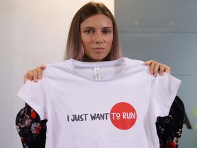 Belarusian Olympic athlete Krystsina Tsimanouskaya poses with t-shirt with the lettering reading 'I just want to run' during a press conference on August 5, 2021 in Warsaw, one day after her arrival in Poland.