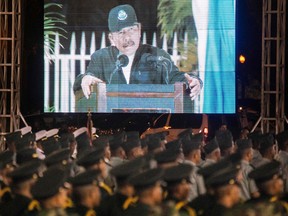 Soldiers stand at attention near a screen showing Nicaraguan President Daniel Ortega delivering a speech on Feb. 21, 2020.