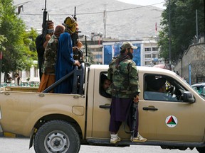 Taliban fighters patrol a street in Kabul on Aug. 17.