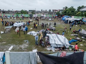 People make repairs and create shelter, after spending the night outside in the aftermath of the earthquake, facing the severe inclement weather of Tropical Storm Grace near Les Cayes, Haiti on Aug. 17, 2021.