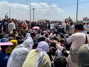 Afghan people gather along a road as they wait to board a U.S. military aircraft to leave the country, at a military airport in Kabul on Aug. 20, 2021 days after Taliban's military takeover of Afghanistan.