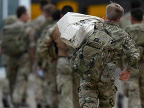 Members of the British armed forces 16 Air Assault Brigade walk to the air terminal as the troops return from assisting with the evacuation of people from Kabul airport.