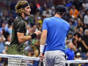 Greece's Stefanos Tsitsipas (L) shakes hands with Britain's Andy Murray after winning their 2021 US Open men's singles match at the USTA Billie Jean King National Tennis Center in New York, on August 30, 2021.
