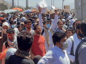 Crowds of people hoping to be evacuated show their documents to U.S. troops outside the airport in Kabul, Afghanistan August 26, 2021.