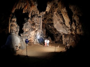 Director of the prehistoric cave of Ardales, Pedro Cantalejo, 64, and Gerardo, a guide, stand in the "Room of the Stars," in a prehistoric cave where red ocher markings were painted on stalagmites by Neanderthals about 65,000 years ago, according to an international study, in Ardales, southern Spain, on Aug. 7, 2021.