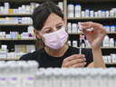 Barbara Violo, pharmacist and owner of The Junction Chemist Pharmacy, draws up a dose of the Pfizer-BioNTech COVID-19 vaccine, in Toronto, Friday, June 18, 2021.
