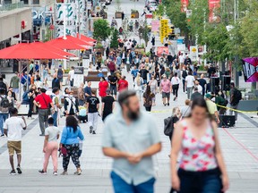 People walk along a street in Montreal, Saturday, July 31, 2021, as the COVID-19 pandemic continues in Canada and around the world.