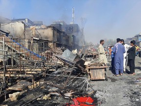 Afghans inspect damaged shops after fighting between Taliban and Afghan security forces in Kunduz city, northern Afghanistan, Sunday, Aug. 8, 2021.