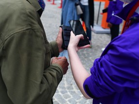 A visitor, left, has their smartphone Covid-19 health pass checked before entering the George Pompidou Center in Paris, France, on Friday, Aug. 6, 2021.