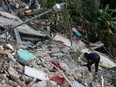 A resident searches through the rubble of destroyed houses, after the earthquake that took place on August 14th, in Marceline, near Les Cayes, Haiti August 20, 2021.