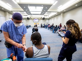 A health-care worker from Humber River hospital's mobile vaccination team administers the Moderna COVID-19 vaccine at the Church of Pentecost Canada in Toronto, on May 4.
