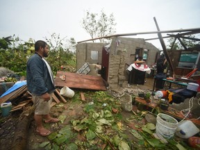Residents survey a damaged home after Hurricane Grace made landfall in Tecolitla, Veracruz state, Mexico, on Saturday, Aug. 21, 2021.
