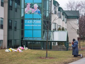 A woman prays as she leaves flowers outside Residence Herron, a senior's long-term care facility, following a number of deaths since the coronavirus disease (COVID-19) outbreak, in the suburb of Dorval in Montreal Quebec, Canada April 13, 2020.