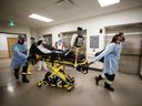 Paramedics and healthcare workers transfer a patient from Humber River Hospital's Intensive Care Unit to a waiting air ambulance as the hospital frees up space In their ICU unit, in Toronto, Ontario, Canada, on April 28, 2021.