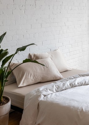 KOTN’s Sheet Set in Cashmere and Duvet Cover in White Microstripe.