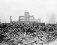 In this Sept. 8, 1945 file photo, an allied correspondent stands in the rubble in front of the shell of a building that once was a exhibition center and government office  in Hiroshima, Japan, a month after the first atomic bomb ever used in warfare was dropped by the U.S. on Aug. 6, 1945.