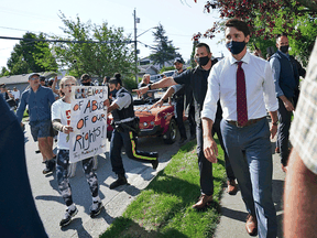 A protester yells at Liberal Leader Justin Trudeau as he campaigns in Surrey, B.C., on Wednesday, Aug 25, 2021.