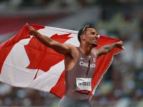 Andre De Grasse of Canada celebrates with his national flag after winning gold in the 200m.