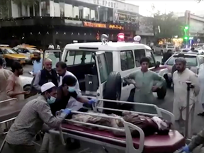 A screen grab shows people carrying an injured person to a hospital after an attack at Kabul airport, in Kabul, Afghanistan August 26, 2021.